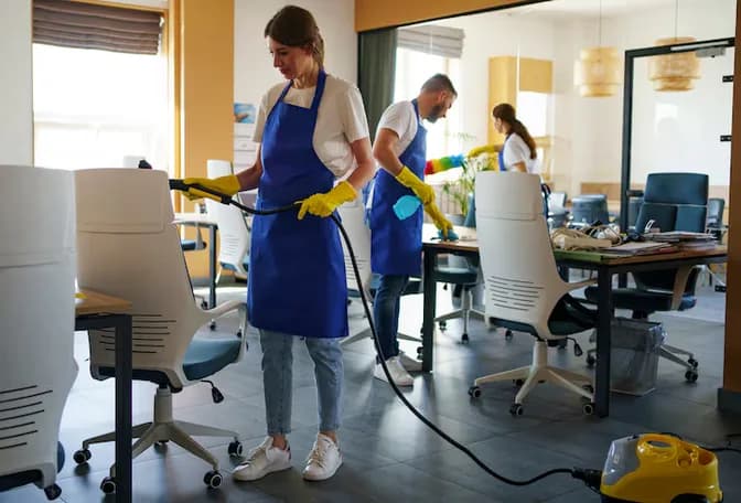 Professional cleaners servicing a modern open-plan office